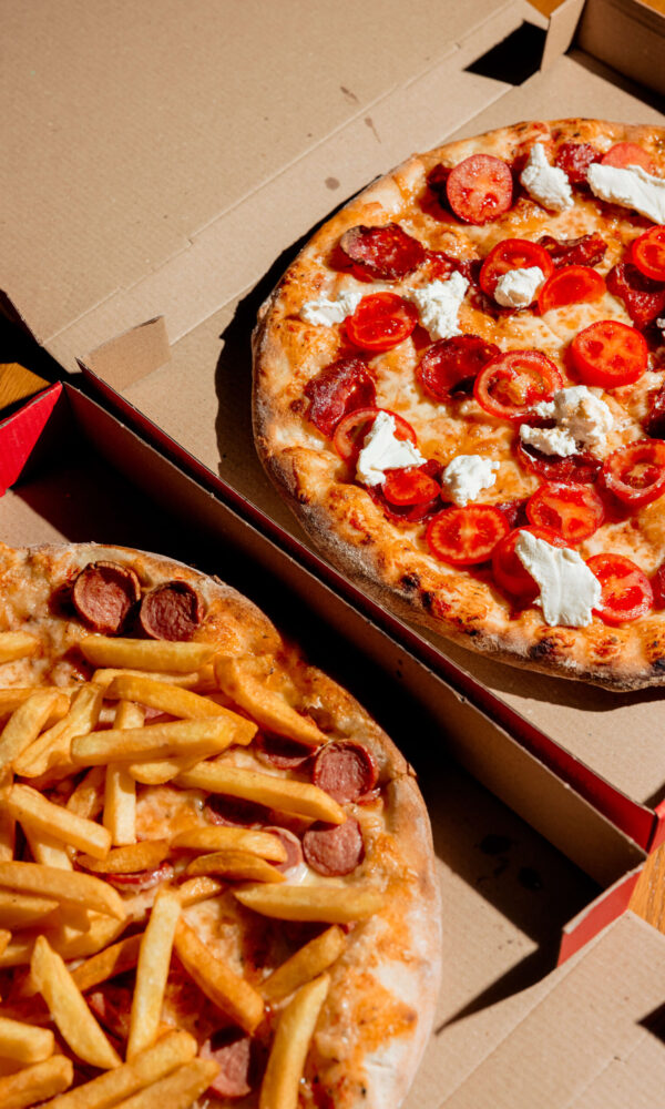 two-pizzas-boxes-one-with-fries-hot-dogs-other-with-tomatoes-cheese two-pizzas-boxes-one-with-fries-hot-dogs-other-with-tomatoes-cheese